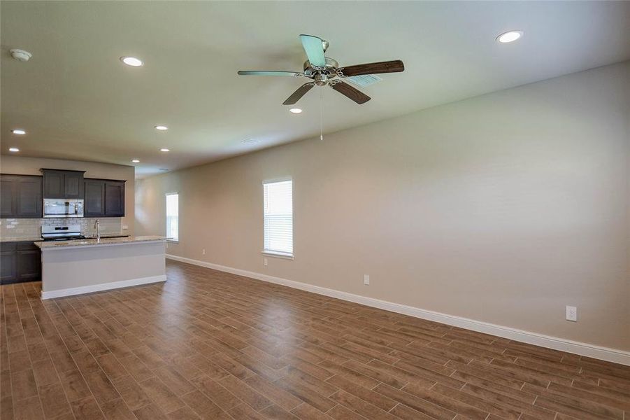 Unfurnished living room featuring dark wood-style floors, recessed lighting, and ceiling fan Unfurnished living room featuring dark wood-style floors, recessed lighting, and ceiling fan