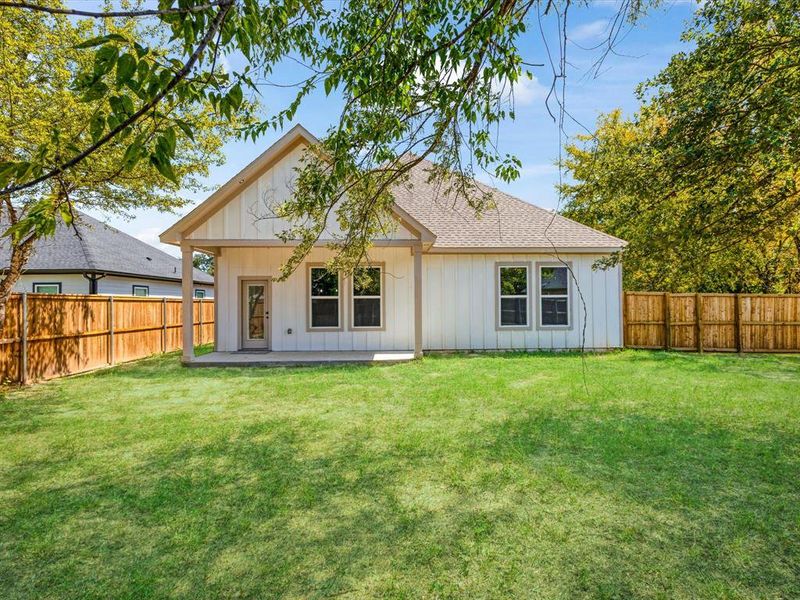 Back of house with a fenced backyard, board and batten siding, a patio, and roof with shingles Back of house with a fenced backyard, board and batten siding, a patio, and roof with shingles