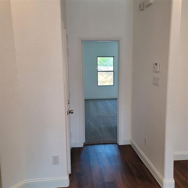 Corridor featuring dark colored carpet