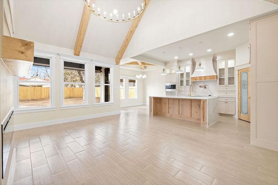 Kitchen with a chandelier, a sink, open floor plan, light countertops, and beam ceiling