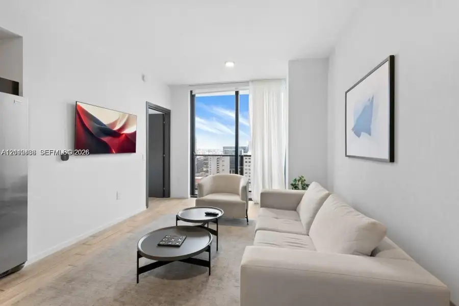Living area featuring floor-to-ceiling windows, wood-finish flooring, and recessed ceiling lighting Living area featuring floor-to-ceiling windows, wood-finish flooring, and recessed ceiling lighting