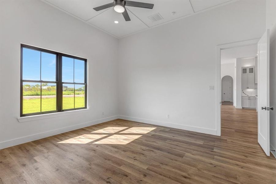 Spare room featuring light wood-style floors, recessed lighting, ceiling fan, and arched walkways