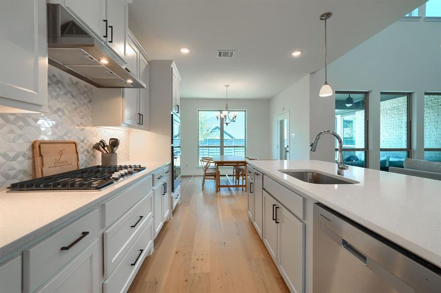 Kitchen with appliances with stainless steel finishes, a healthy amount of sunlight, sink, and backsplash