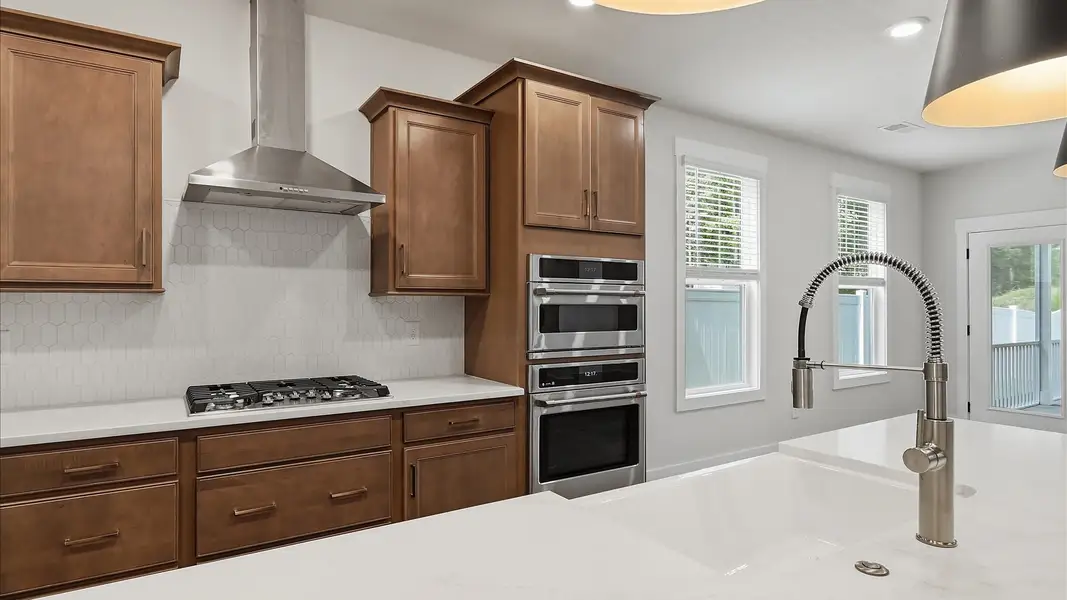 Exclusive kitchen design with large island, pendant lights, and tasteful finishes throughout at Harrier Point