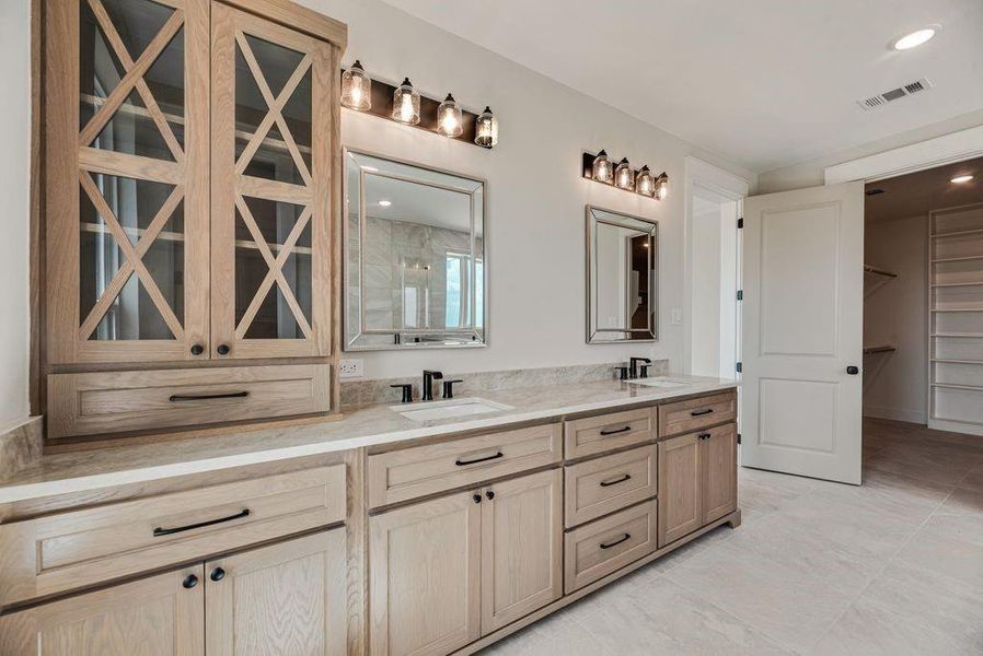 Full bathroom with double vanity, a spacious closet, and recessed lighting