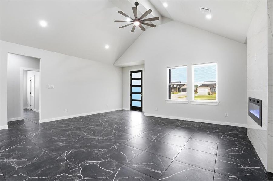 Spacious living area featuring vaulted ceilings, recessed lighting, and a modern ceiling fan