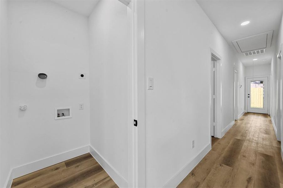 Washroom featuring wood-type flooring, hookup for a washing machine, and hookup for an electric dryer