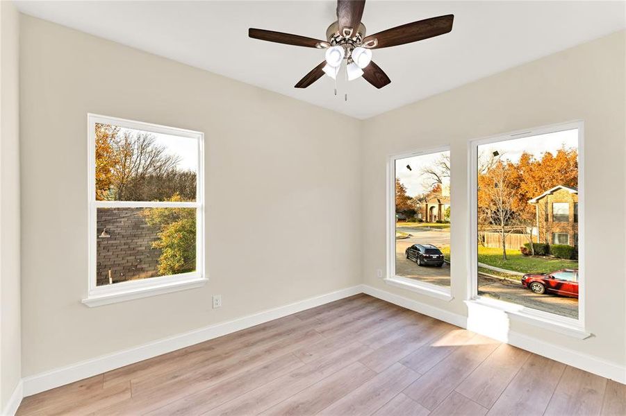 Unfurnished room with ceiling fan, plenty of natural light, and light wood-type flooring