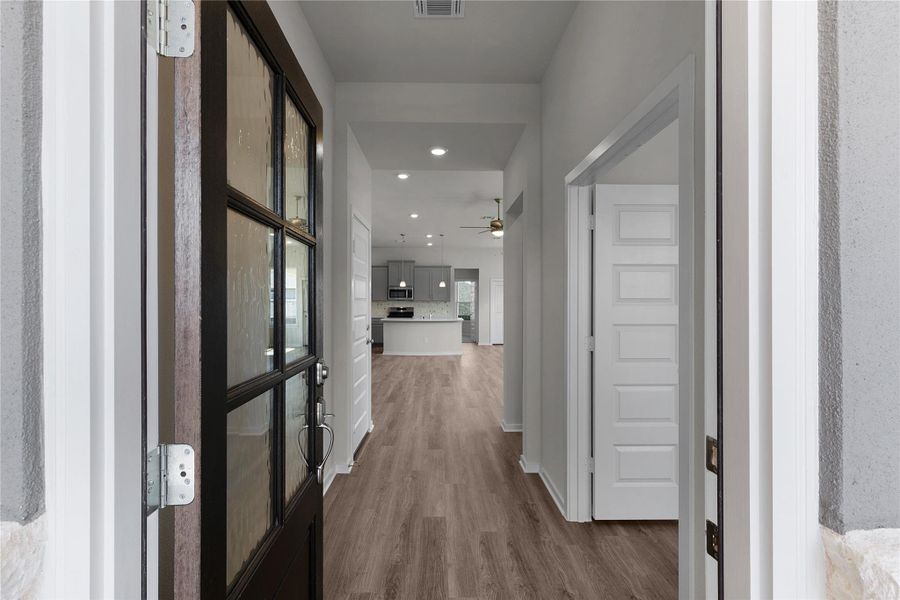 Corridor with dark wood-type flooring and recessed lighting