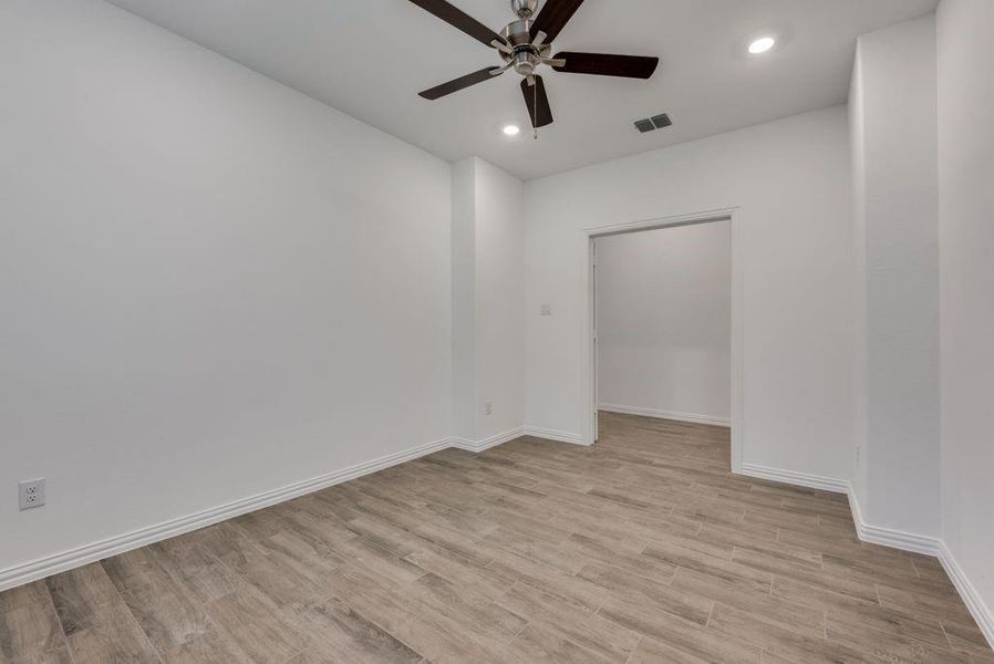 Spare room featuring ceiling fan and light wood-type flooring