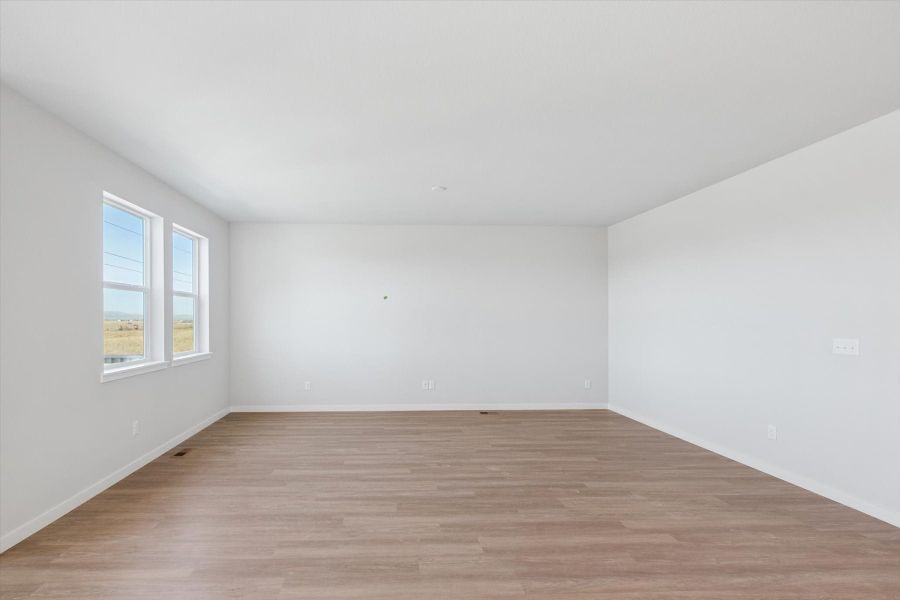 A room with a wood floor and a window.