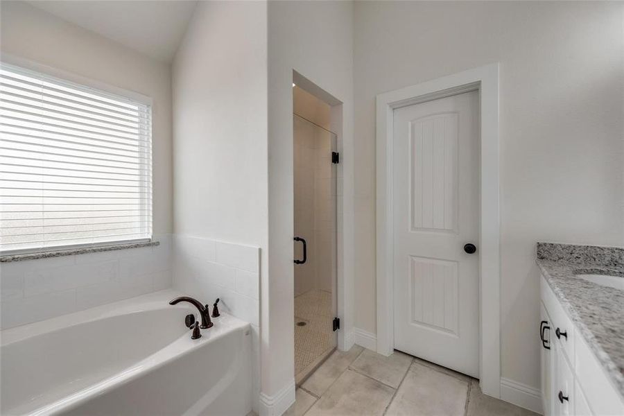 Full bath featuring vanity, a bath, light tile patterned floors, and a shower stall