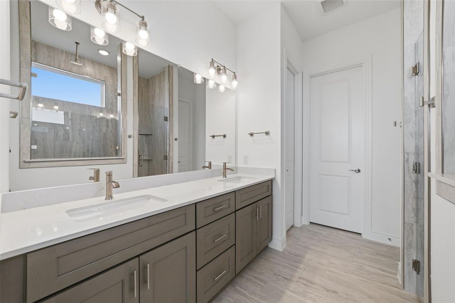 A spacious mega shower paired with double vanity sinks creates a luxurious, spa-like primary bathroom.