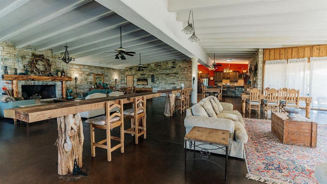 Living area featuring a fireplace, ceiling fan, and brick wall
