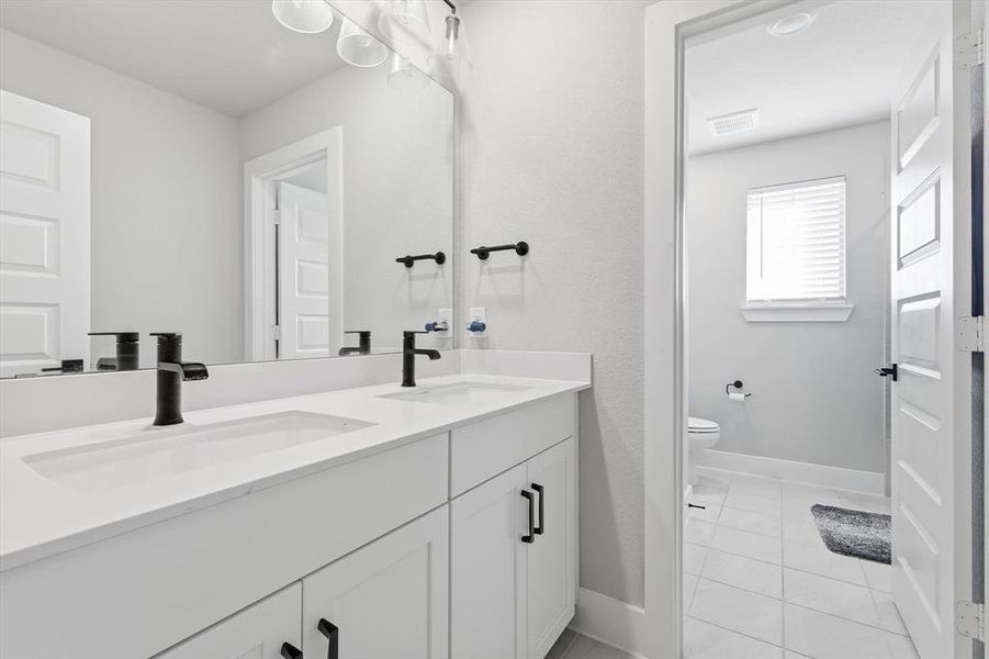 Full bathroom featuring double vanity and light tile patterned floors