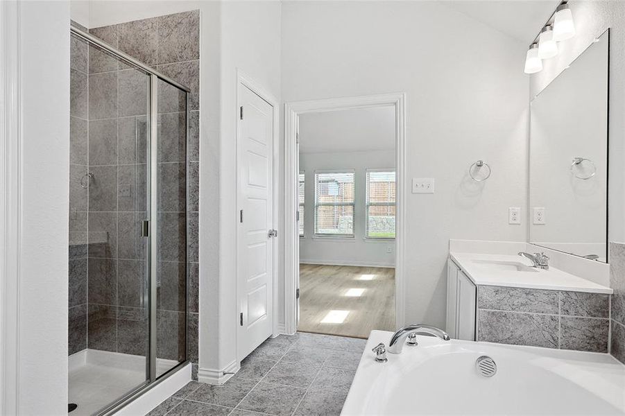 Bathroom with vanity, tile flooring, and plus walk in shower