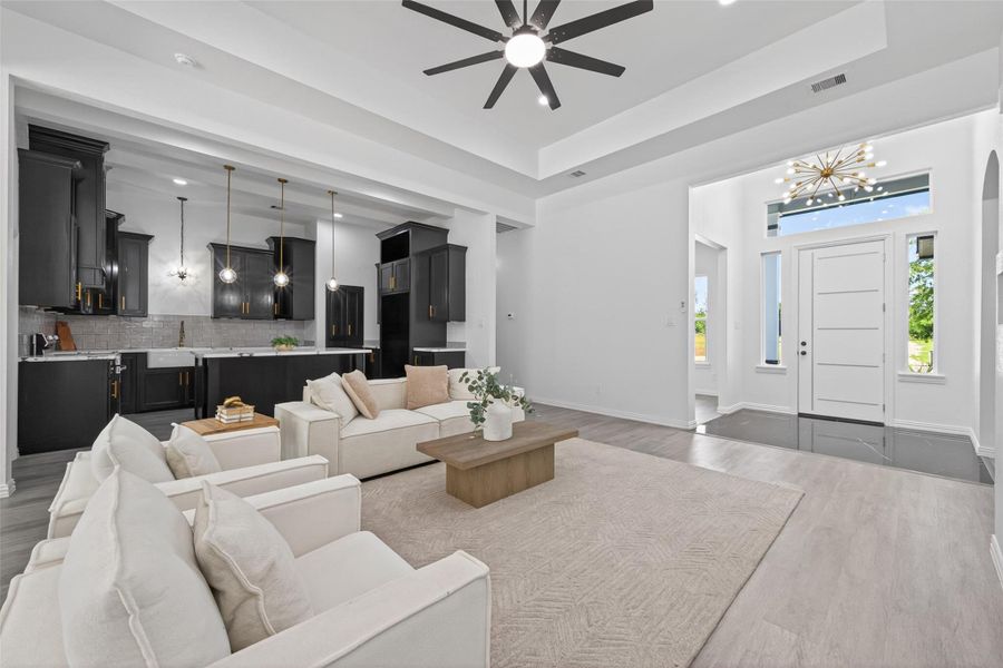 Bright and spacious open-concept living area featuring beautiful laminate flooring, abundant natural light, and custom finishes throughout.