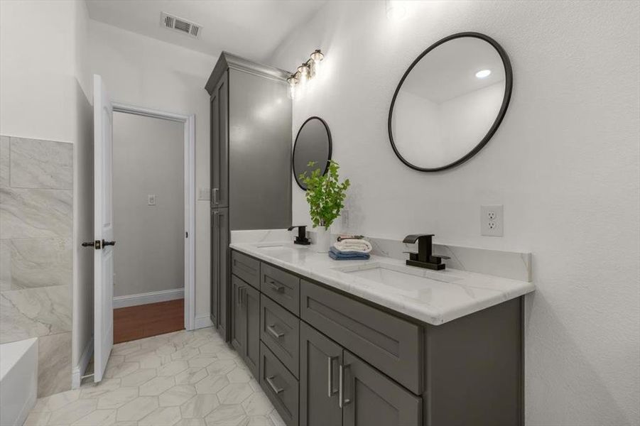 Bathroom featuring vanity, a bathing tub, and tile patterned floors