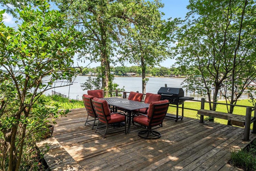 Expansive wood deck with a built-in bench, offering a waterfront setting