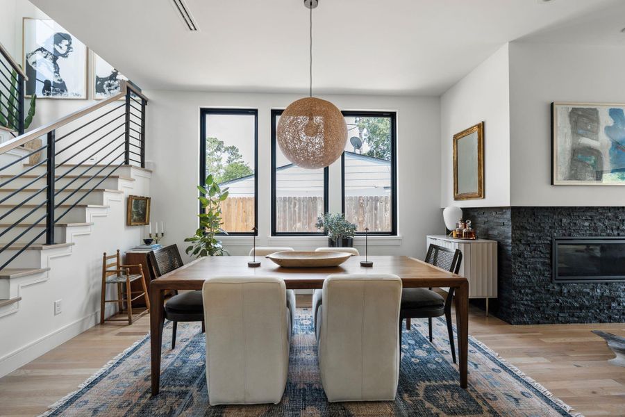 A closer view of the dining space highlights the natural light, clean lines, and a nearby fireplace, creating and inviting setting for everyday meals or entertaining.