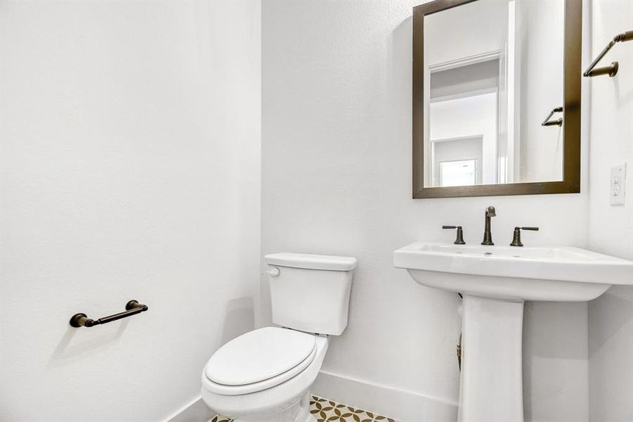 Half bathroom featuring toilet and baseboards