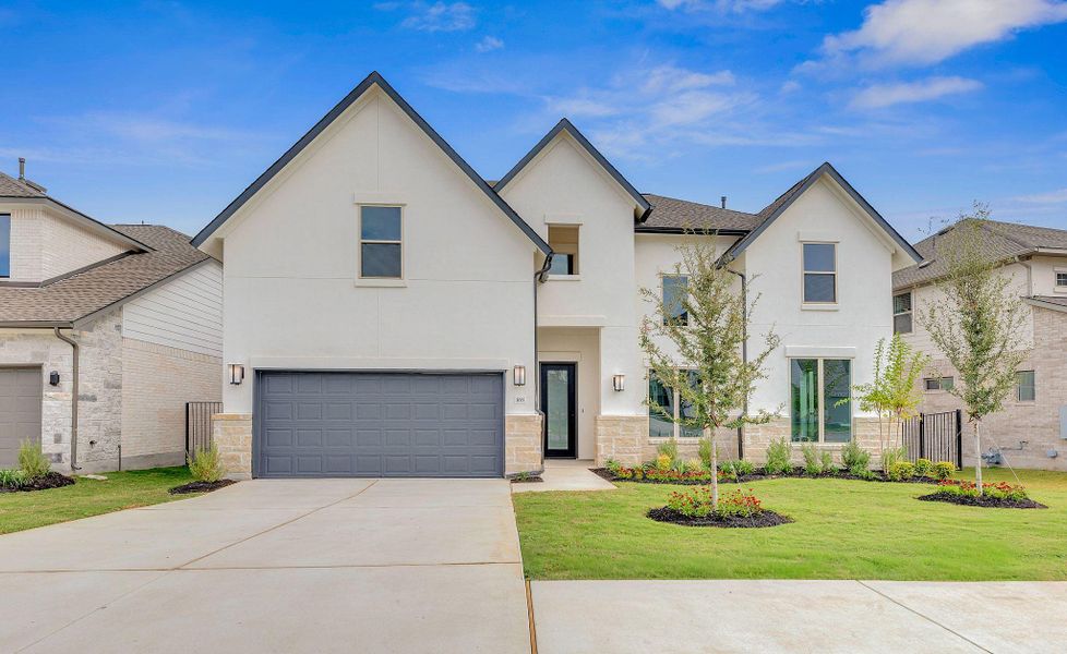 Front exterior of a new home in Santa Rita Ranch, Liberty Hill, TX, highlighting curb appeal (Image 26). Front exterior of a new home in Santa Rita Ranch, Liberty Hill, TX, highlighting curb appeal (Image 26).