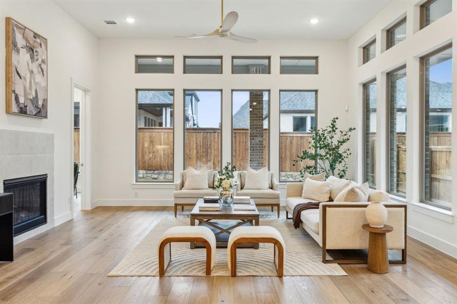 Sunroom with ceiling fan and a tile fireplace