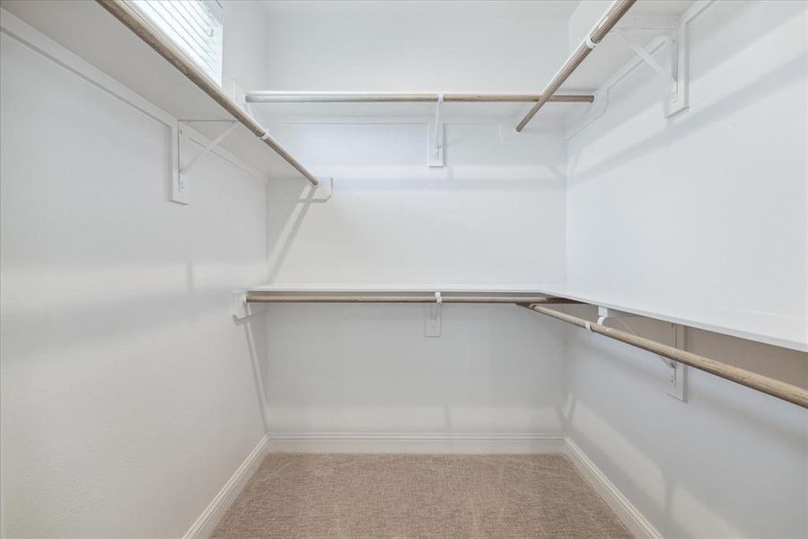 This walk-in closet in the primary bedroom provides abundant hanging space and shelving for organized storage, offering plenty of room to keep your wardrobe and accessories neatly arranged.