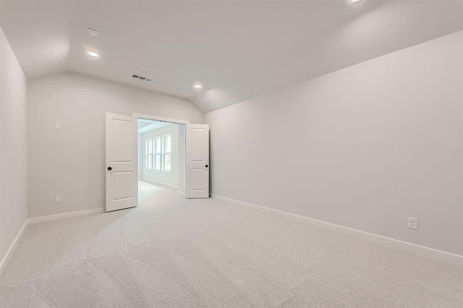 Unfurnished room featuring vaulted ceiling, baseboards, light carpet, and recessed lighting