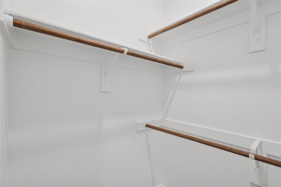 The property includes a closet with white walls and wooden rods for hanging clothes