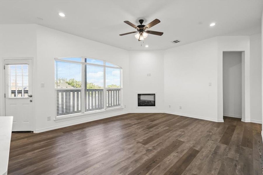 Unfurnished living room featuring dark hardwood / wood-style floors and ceiling fan