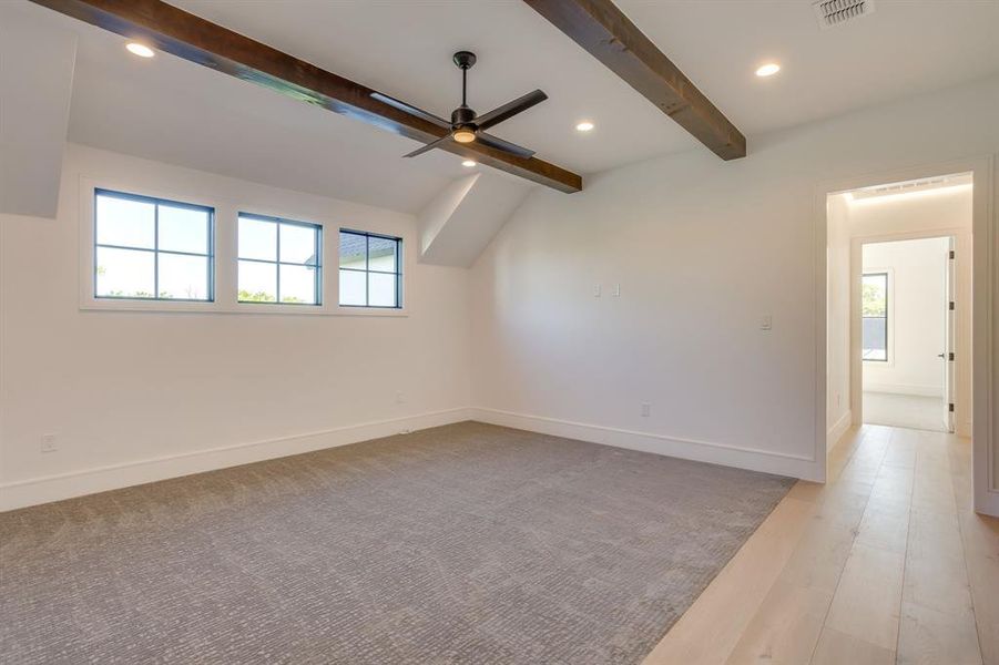 Unfurnished room featuring ceiling fan, recessed lighting, plenty of natural light, vaulted ceiling with beams, and light wood finished floors