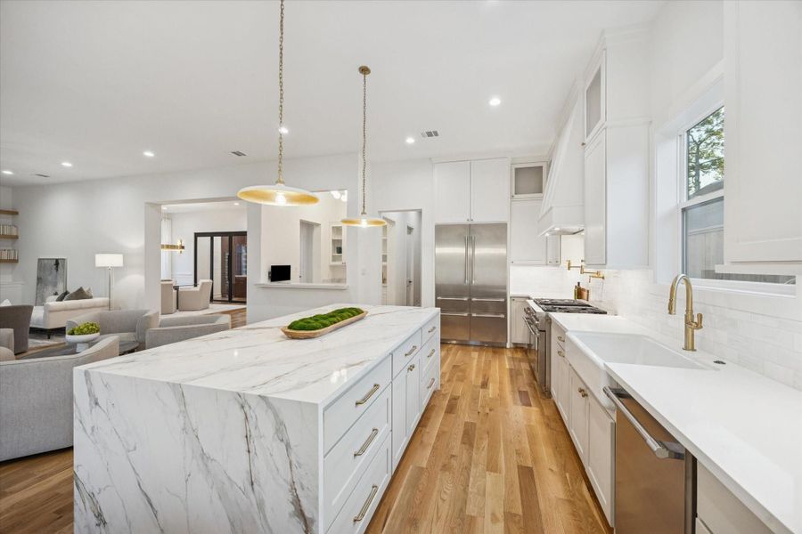 Multiple work zones make the kitchen highly functional, with a large waterfall island for prep and gathering, a dedicated cooking wall, and clear circulation to the living and dining areas. Abundant cabinetry, professional grade appliances, and thoughtful lighting keep the space efficient without sacrificing style. Multiple work zones make the kitchen highly functional, with a large waterfall island for prep and gathering, a dedicated cooking wall, and clear circulation to the living and dining areas. Abundant cabinetry, professional grade appliances, and thoughtful lighting keep the space efficient without sacrificing style.