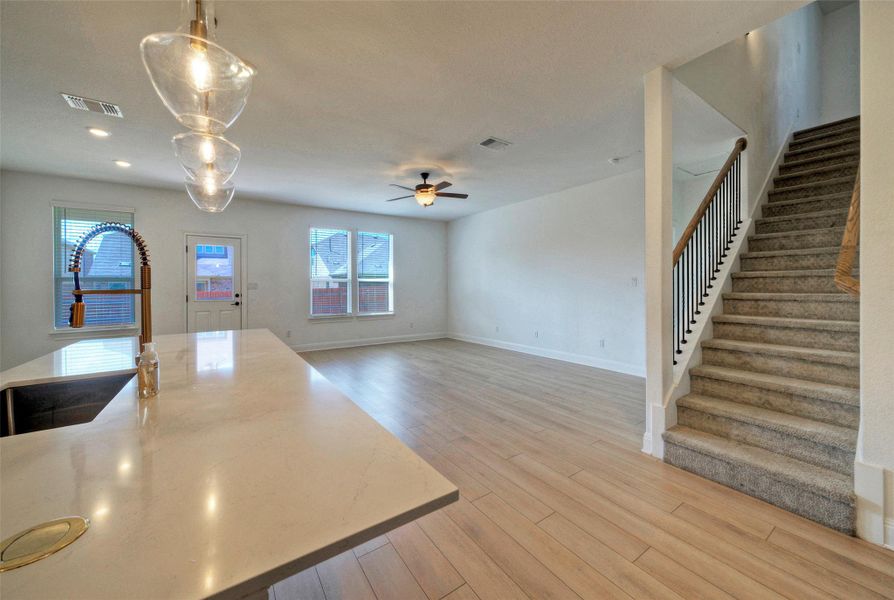 An open floor plan connects the kitchen island to a spacious living area and staircase. An open floor plan connects the kitchen island to a spacious living area and staircase.