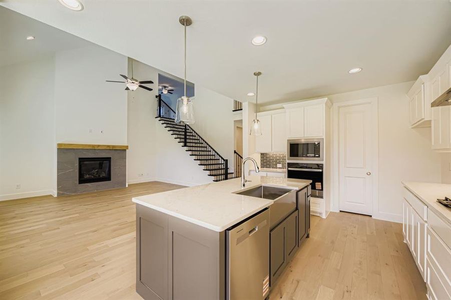 Kitchen with recessed lighting, white cabinetry, a kitchen island with sink, pendant lighting, and backsplash Kitchen with recessed lighting, white cabinetry, a kitchen island with sink, pendant lighting, and backsplash