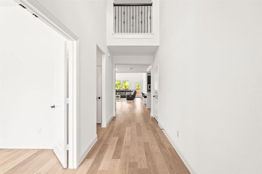 Corridor featuring light wood-style floors and a high ceiling