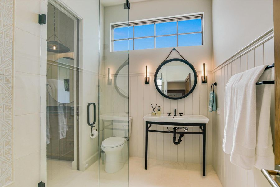 Bathroom featuring a stall shower and a wainscoted wall
