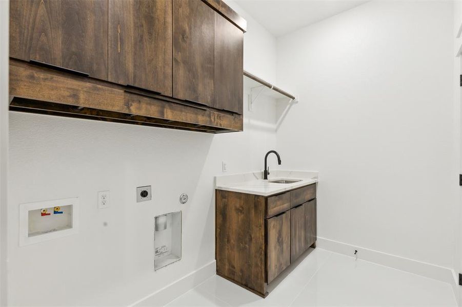 Washroom featuring hookup for a washing machine, light tile patterned floors, cabinets, sink, and electric dryer hookup