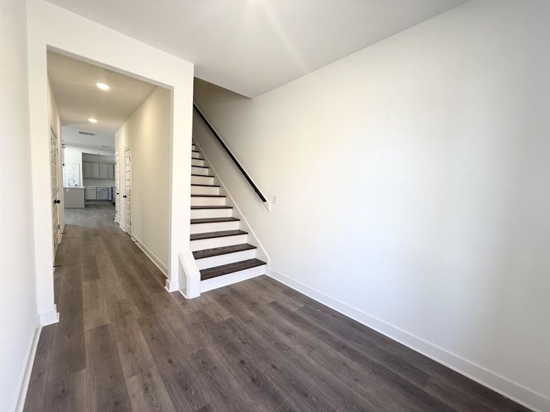 Stairway featuring wood finished floors and recessed lighting