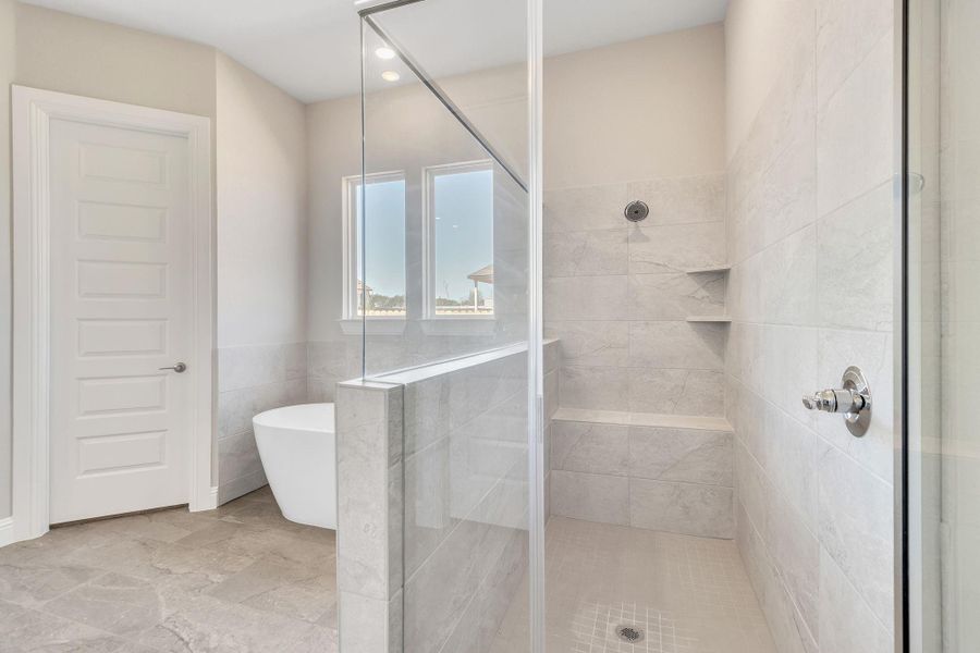 Full bath featuring a soaking tub, a shower stall, and tile walls Full bath featuring a soaking tub, a shower stall, and tile walls