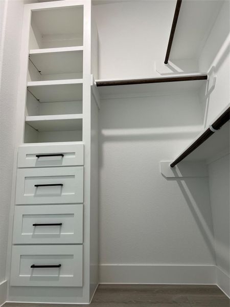 Spacious closet with built-in cabinets and shelves for organized storage.