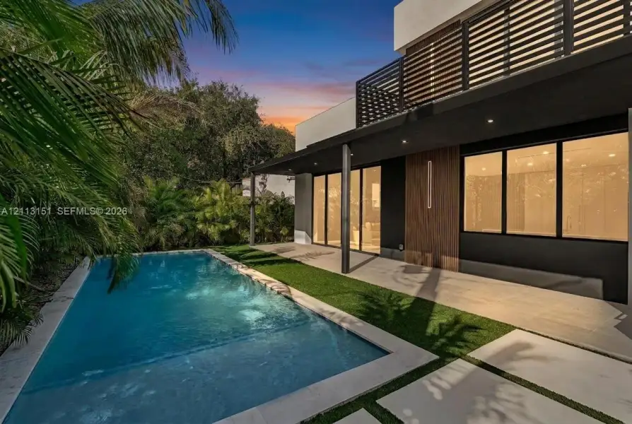 Contemporary exterior featuring a private swimming pool, concrete paver patio, integrated covered terrace, vertical wood-finish siding, and a slatted balcony railing Contemporary exterior featuring a private swimming pool, concrete paver patio, integrated covered terrace, vertical wood-finish siding, and a slatted balcony railing