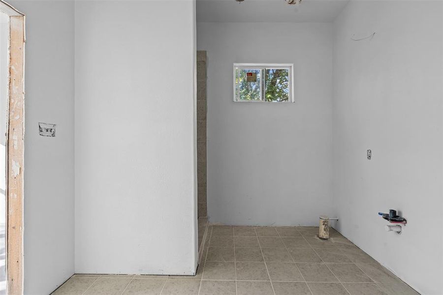 Laundry area featuring light tile patterned floors Laundry area featuring light tile patterned floors