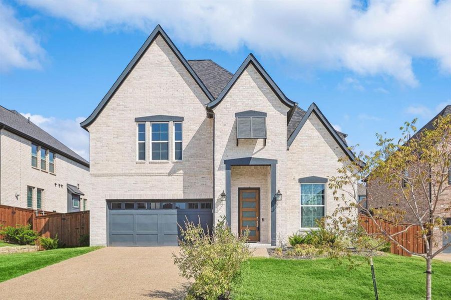 View of front of property with a garage and a front yard