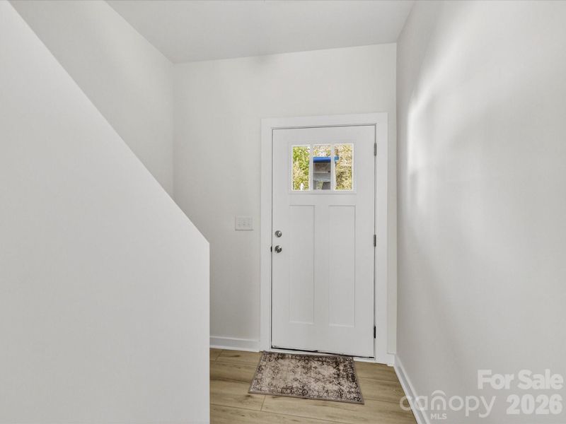 Bright and welcoming foyer featuring clean modern finishes, durable flooring, and a convenient staircase leading to the upper level. Bright and welcoming foyer featuring clean modern finishes, durable flooring, and a convenient staircase leading to the upper level.