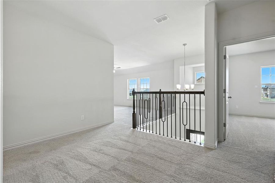 Corridor with carpet, a chandelier, and an upstairs landing