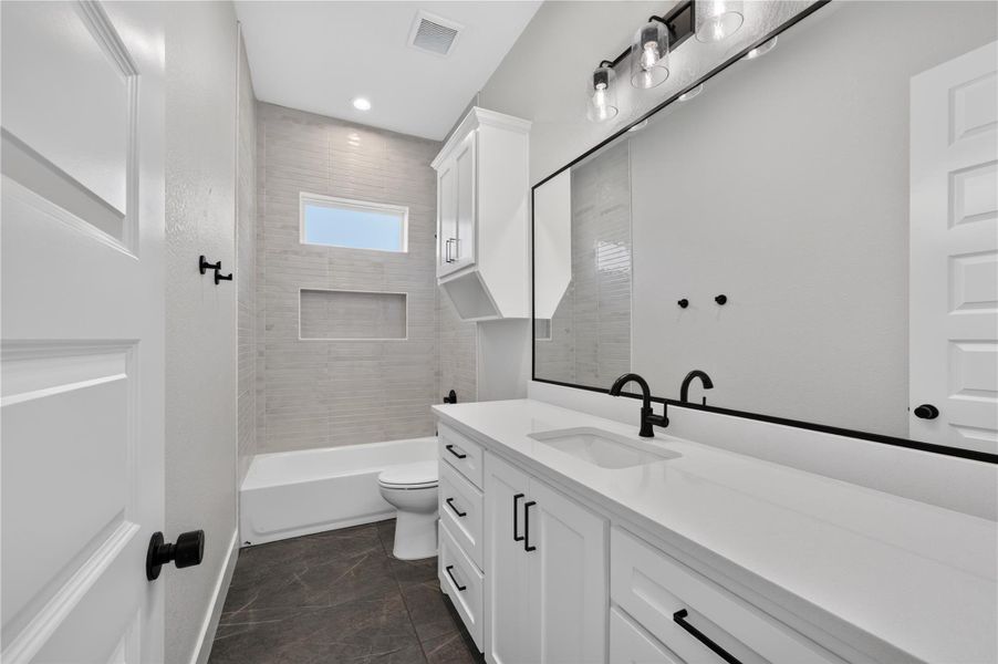 Crisp finishes and modern tile create a serene atmosphere in this secondary bathroom.
