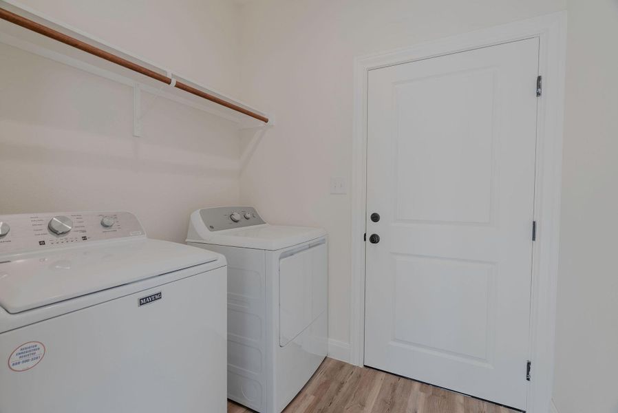 Laundry room with light wood-style flooring and separate washer and dryer Laundry room with light wood-style flooring and separate washer and dryer