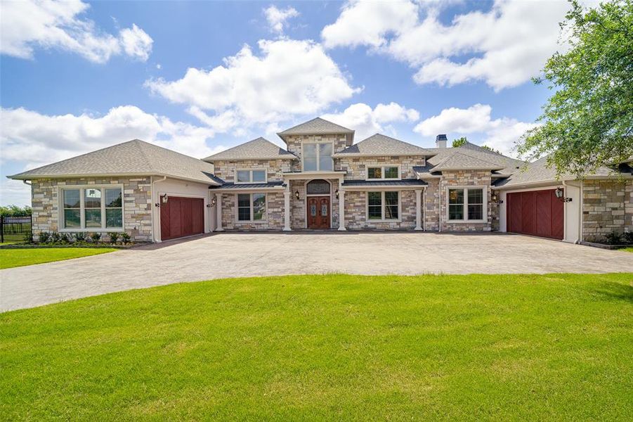 Expansive stone veneer facade featuring multiple gables and a central entry with double wood doors