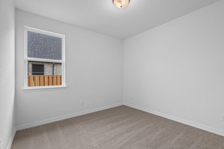 Your secondary bedroom features plush carpet, fresh paint, closet, and a large window that lets in plenty of natural lighting.